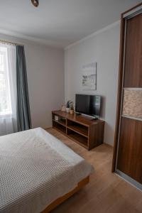 里加Nice&cozy flat No7的一间卧室配有一张床和一台平面电视