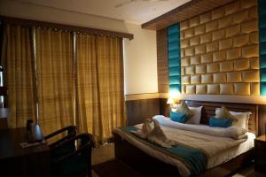 乔斯希马特Hotel Joshimath Inn的一间卧室配有一张床、一张桌子和一张四柱床。