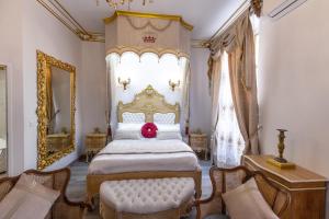 纳博讷Suite Royale Maison de l'église du couvent的一间卧室配有一张大床,上面有红色枕头