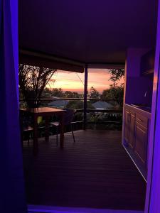 帕皮提Ononui Airport Studio的客房设有桌子和享有日落美景的阳台。