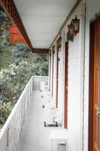 Ban Wang Khun Knachenภูไพรเลค รีสอร์ท的房屋内的阳台配有白色椅子