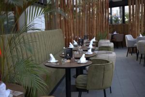 丹吉尔Flamant Rose Appart Hotel的用餐室配有桌椅和植物