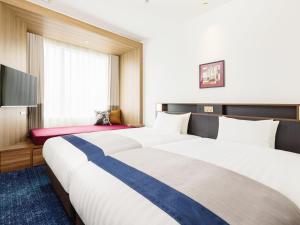 东京&Here TOKYO UENO的酒店客房设有两张床和一台平面电视。