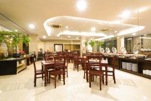 日惹潘达纳兰普拉维塔玛日惹酒店的一间带木桌椅的餐厅和一间酒吧