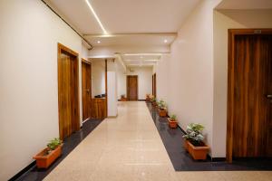 纳西克FabHotel Priya Lodging, near Ojhar Airport的带有盆栽植物的办公楼走廊