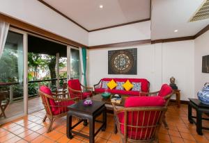 卡塔海滩Katamanda villa Sooksan的客厅配有红色椅子和红色沙发