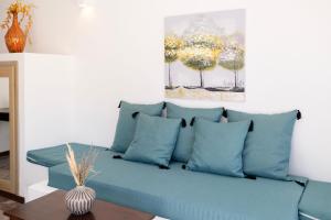卡马利DELION SEA APARTMENTS的客厅配有带蓝色枕头的沙发
