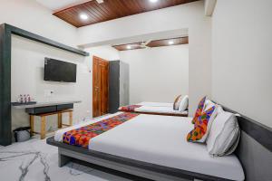 纳西克FabHotel Priya Lodging, near Ojhar Airport的一间卧室配有一张床和一台电视