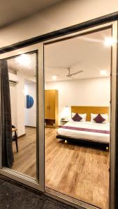 古尔冈Mavens White Artemis Hospital Road Sector 52 Gurgaon的一间卧室配有一张床和一面大镜子