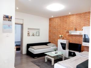 斯拉沃尼亚布罗德Apartment Centar的客厅配有黑色沙发和砖墙