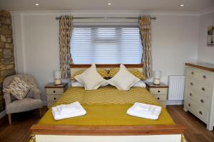 Chew MagnaGuest Suite King Bed in Chew Valley Bath Somerset的一间卧室配有黄色的床和2条毛巾