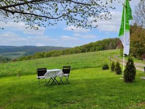 比尔克斯Ferienwohnung Landidylle的一张桌子和两把椅子,放在一个有旗帜的场地