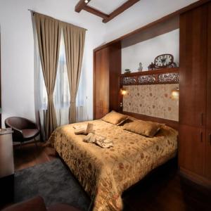 松博特海伊Vinci Apartman Szombathely的一间卧室配有一张大床和一把椅子