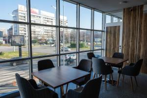 普罗夫迪夫HOTEL BAYKO的客房设有桌椅和大窗户。