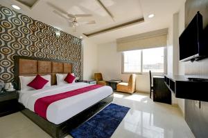 新德里De Atlantis Inn Hotel Near Delhi Airport的一间卧室配有一张床、一张书桌和一台电视