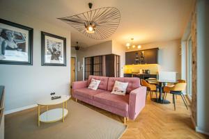 格丁尼亚Gdynia po horyzont的客厅配有粉红色的沙发和桌子