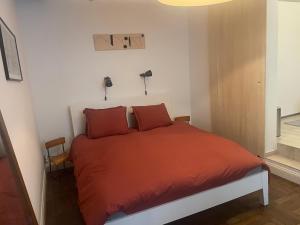 布鲁塞尔Petite Impasse privée "Impasse Poils"的一间卧室配有红色枕头的床
