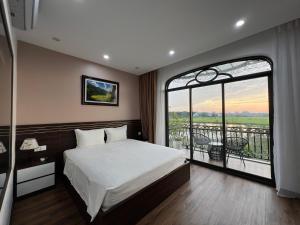 宁平Lotus Hotel Ninh Bình的一间卧室设有一张大床和一个大窗户