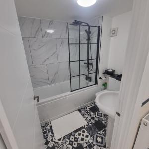 普里茅斯Quite central flat的带淋浴和盥洗盆的白色浴室