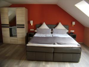 瓦尔德明兴瓦尔德明兴康体酒店的一间卧室配有一张带橙色墙壁的大床