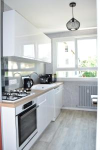 阿朗松Pour une agréable pause au Parc !的厨房配有白色橱柜和炉灶烤箱。