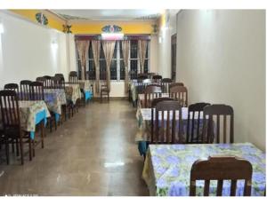 拉瓦格拉Hotel Meanamla, Ravangla, Sikkim的一间带桌椅的用餐室和一间带桌椅的角落间
