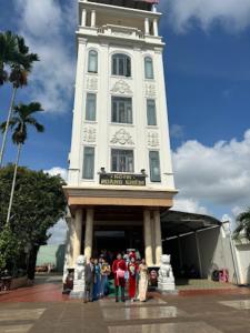波来古市Hoàng Khiêm Hotel的一群站在钟楼前的人