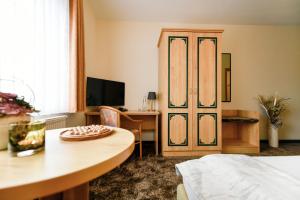 TauerChristinenhof & Spa - Wellnesshotel am Rande des Spreewalds的客房设有一张床、一张桌子和一扇门