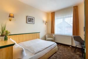 TauerChristinenhof & Spa - Wellnesshotel am Rande des Spreewalds的酒店客房设有床和窗户。