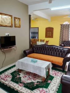 麻坡D'Maryam Homestay的客厅配有沙发和桌子