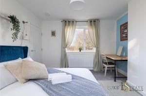 SheepscarLuke Stays - Finchale Ave的卧室配有白色的床、书桌和窗户。