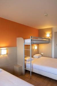 昂德雷济厄布泰翁The Originals Access,Tendance Hôtel, Saint-Etienne的橙色墙壁的客房内设有两张双层床。