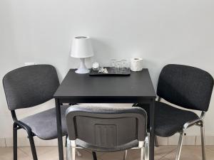 波兹南Apartamenty Gołębia-Economic的一张带两把椅子的黑桌子和一盏灯