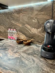 奥拉迪亚Luxury RA Apartment的咖啡壶和柜台上的两瓶水
