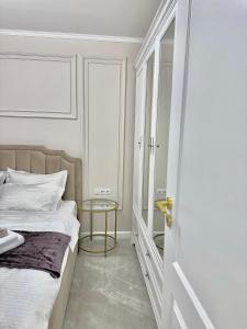 奥拉迪亚Luxury RA Apartment的一间卧室配有一张床和一张玻璃桌