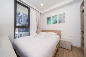 普吉镇Skypark Laguna BangTao Beach Apartment-Long Term Lease的白色的卧室设有一张大床和一个窗户