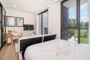 普吉镇Skypark Laguna BangTao Beach Apartment-Long Term Lease的卧室配有一张白色的大床和一张桌子
