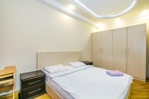 巴库Boulvard M Estate的卧室配有一张白色大床和橱柜。