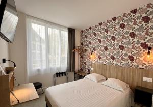 洛里昂Hôtel Le Keroman的一间卧室设有一张床和花卉墙
