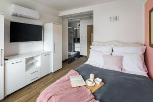 涅兹卡城堡Apartament Castle & Lake Niedzica的一间卧室配有一张带电视和桌子的床。