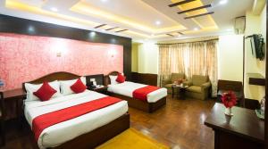 加德满都Samsara Boutique Hotel的酒店客房,设有两张床和一张沙发