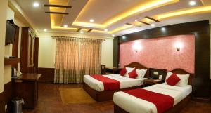 加德满都Samsara Boutique Hotel的酒店客房设有两张床和电视。
