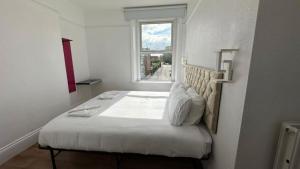 格洛斯特Very Spacious 9 Bedroom House-Garden-Parking for 6的白色卧室设有一张带窗户的床