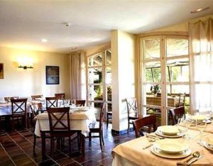 皇后山Casa Rural Marialba的用餐室设有桌椅和窗户。