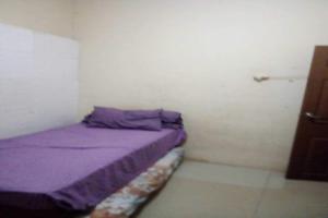 泗水OYO 93863 Dv Homestay Syariah Genteng的小房间,配有紫色的床