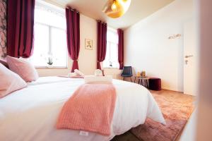 蒙斯Lets Relax - Coté jardin的卧室配有一张带红色窗帘的大型白色床