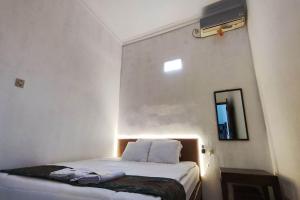 日惹OYO 93867 Minso Inn Sepanjang的一间设有一张床铺的卧室,位于一个带镜子的房间
