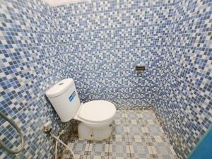 井里汶OYO 93870 Damai Guest House Cirebon的浴室设有蓝色瓷砖墙内的卫生间