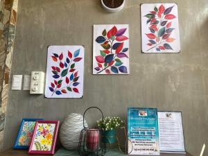 公主港Wilnags Inn Puerto Princesa near airport的墙上四幅画,上面有鲜花
