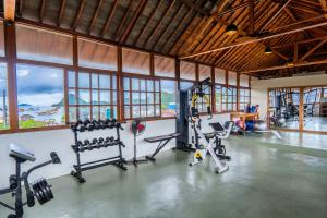 纳闽巴霍Dragon Dive Komodo Dive Resort的一个带跑步机和机器的健身房,位于带窗户的房间里